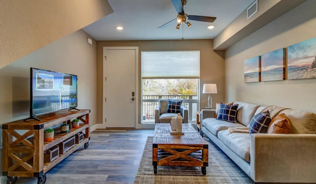 Apartments For Rent In Reno, NV - Riverside Park Apartments - Living Room With High Ceilings, Wood-Style Flooring, a Ceiling Fan, And Expansive Window For Natural Sunlight