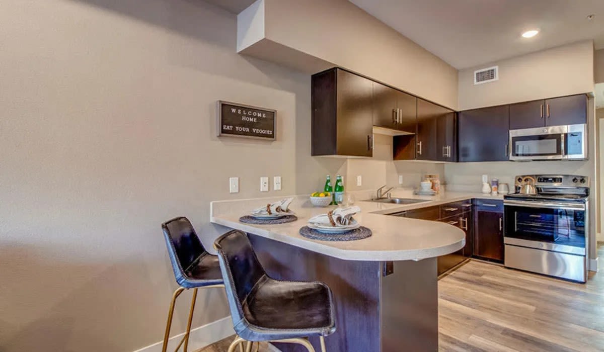 Studio Apartments In Reno, NV - Riverside Park Apartments - Kitchen With Stainless-Steel Appliances, Wood-Style Flooring, Designer Cabinets, And Kitchen Island