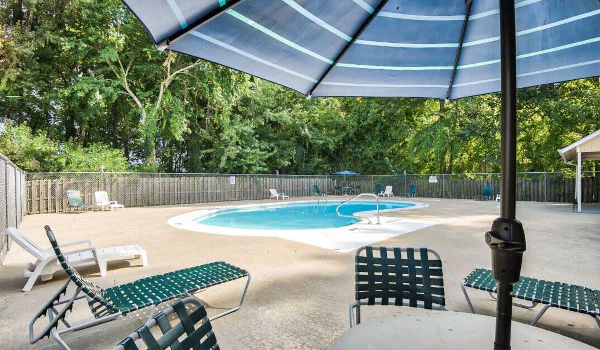 outdoor pool with umbrella at Southgate Manor in Elizabeth City, North Carolina