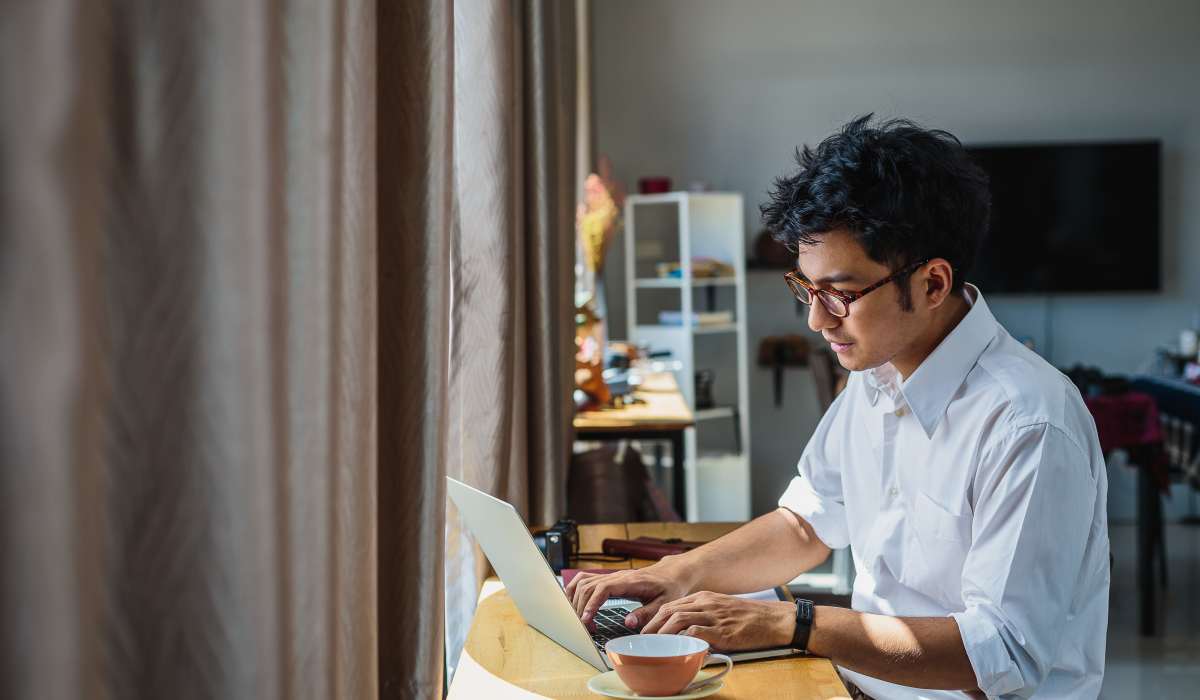 A resident using his laptop in his apartment at Copper Range in Colorado Springs, Colorado