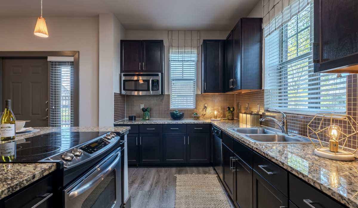 Modern kitchen with a waterfall sink and ambient lighting at Dayrise at Centreport in Fort Worth, Texas