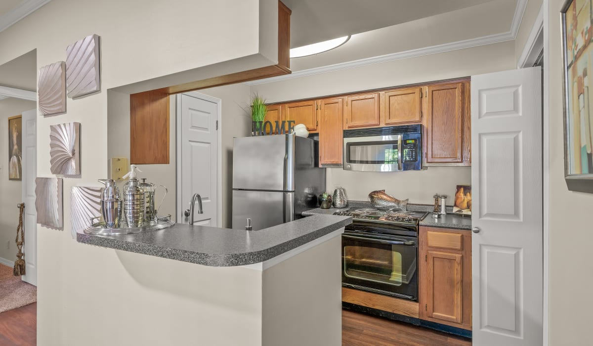 Modern kitchen with wooden cabinets, stainless-steel appliances and granite countertops at The Willows in Shreveport, Louisiana