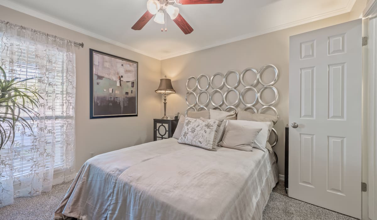 Bedroom with a bed, large window, ceiling fan and wooden flooring at The Willows in Shreveport, Louisiana