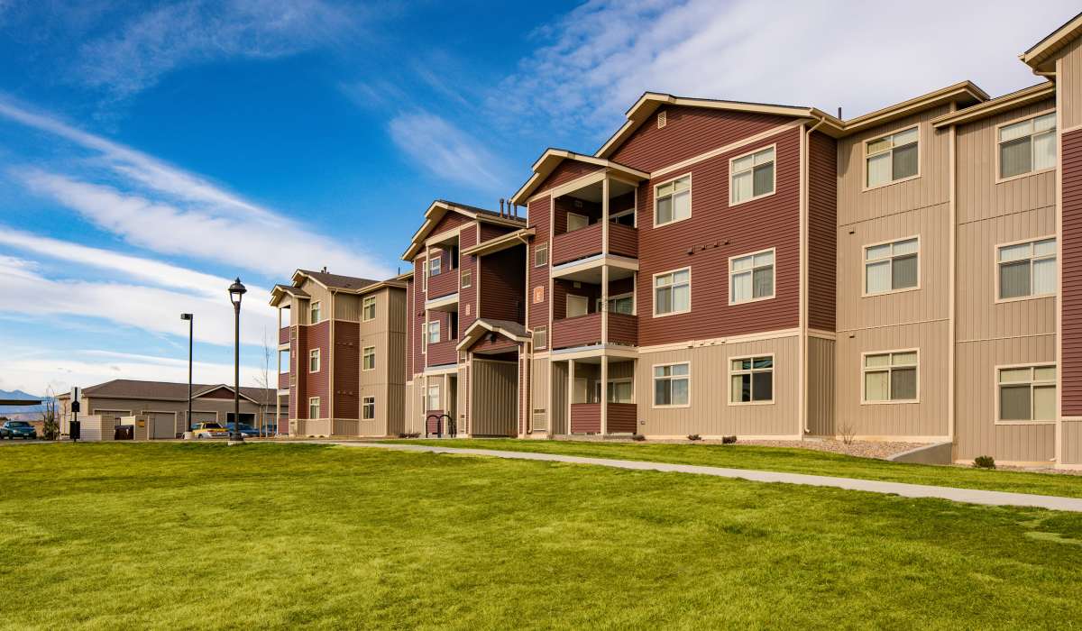 Apartment building surrounded by lush grass at Copper Peak in Longmont, Colorado