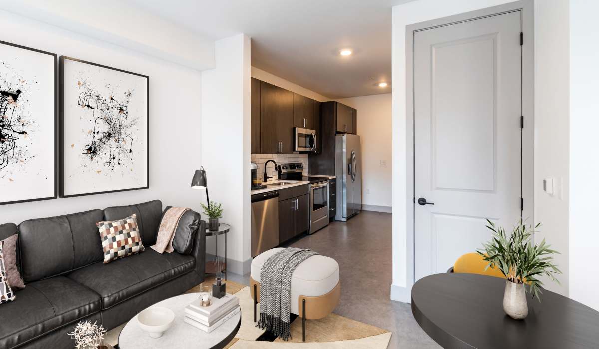 Living room with plenty of natural lighting and a kitchen in a model home at Sphere Apartments in Richmond, Virginia