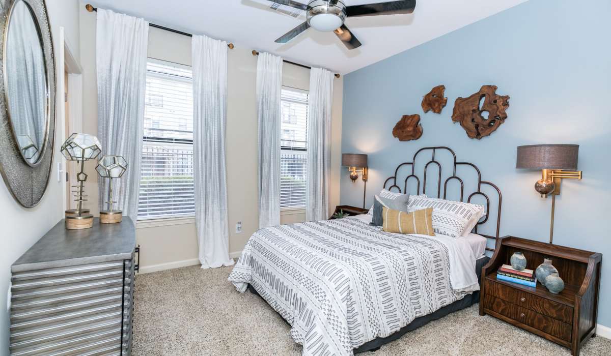 Cozy bedroom with large windows at The Reserve at Johns Creek Walk in Johns Creek, Georgia