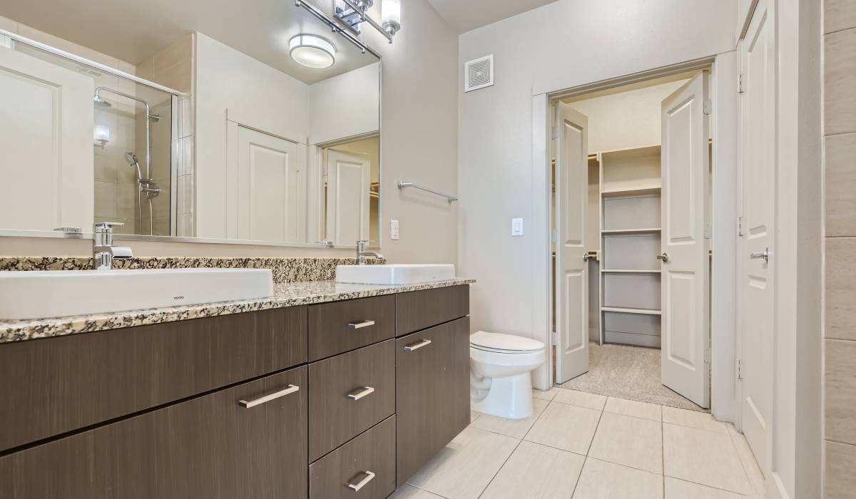 Bathroom with attached walk-in closets at The Lucas Apartments in Dallas, Texas