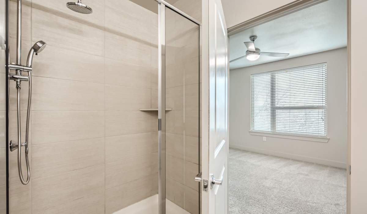 Modern bathroom with bath tub connected to bedroom at The Lucas Apartments in Dallas, Texas