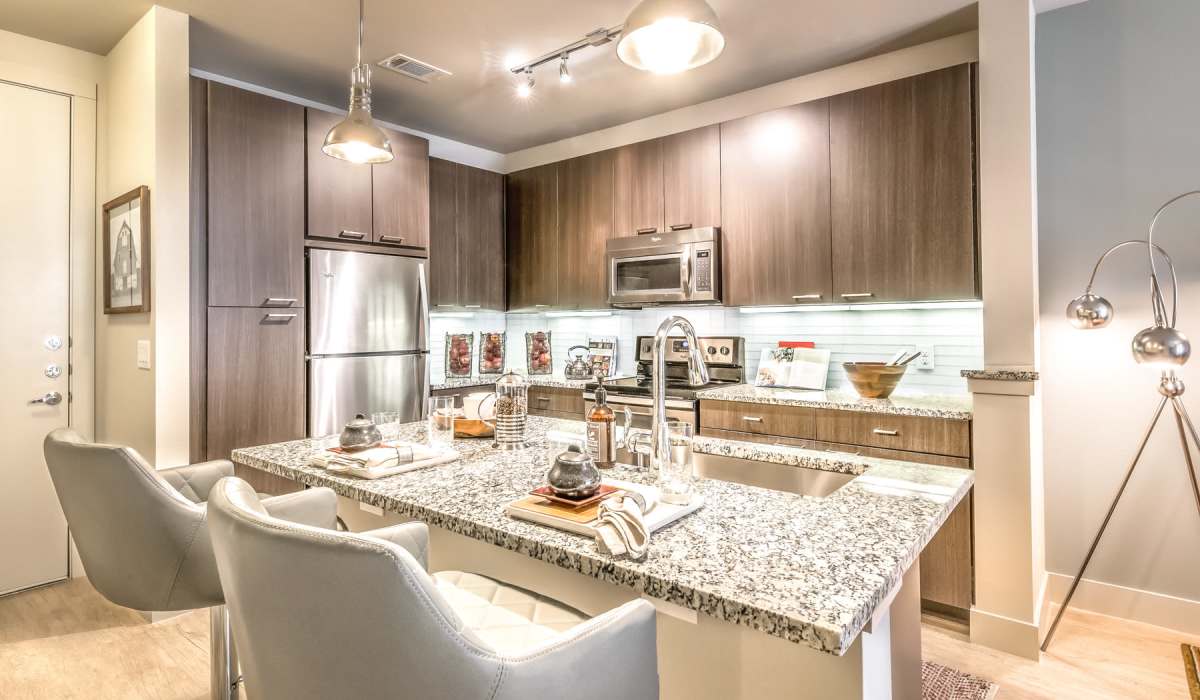 A modern kitchen showcasing the wooden cabinetry and hardwood flooring at The Lucas Apartments in Dallas, Texas