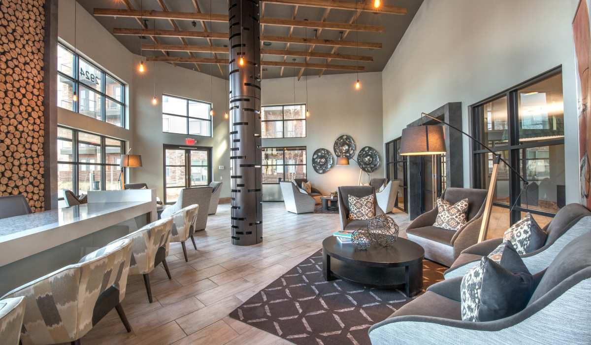 A modern apartment building lobby featuring a stylish bar and inviting clubhouse atmosphere for residents and guests at The Lucas Apartments in Dallas, Texas