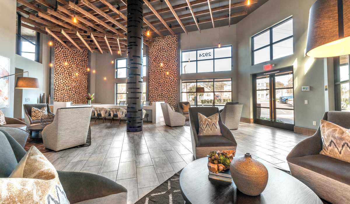 A spacious lobby with a prominent fireplace, providing a comfortable and inviting setting within the clubhouse at The Lucas Apartments in Dallas, Texas