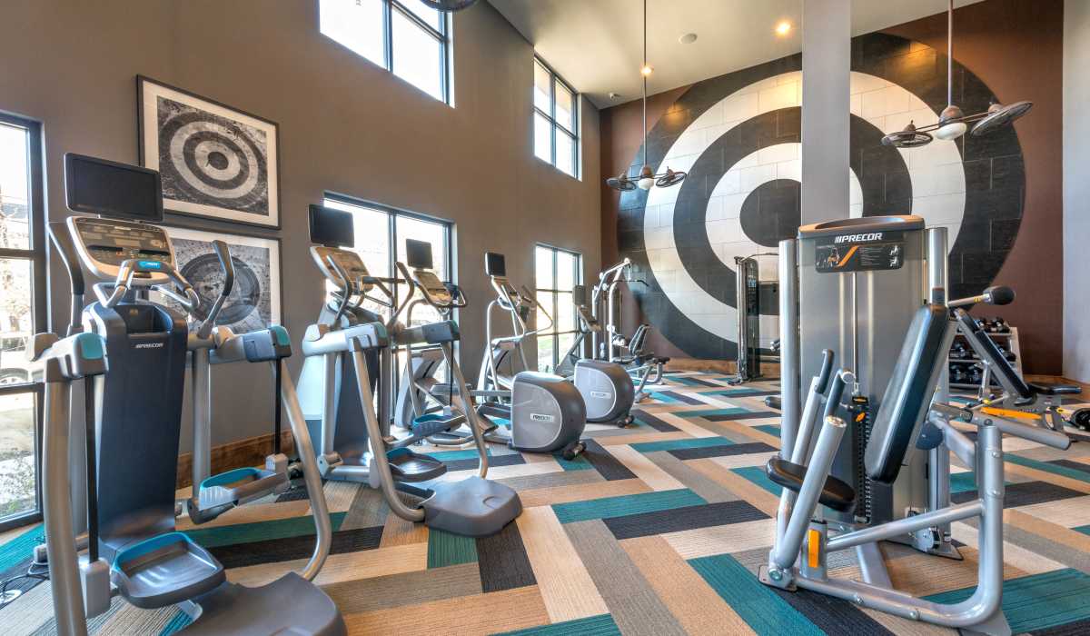 A gym room with modern exercise equipment at The Lucas Apartments in Dallas, Texas