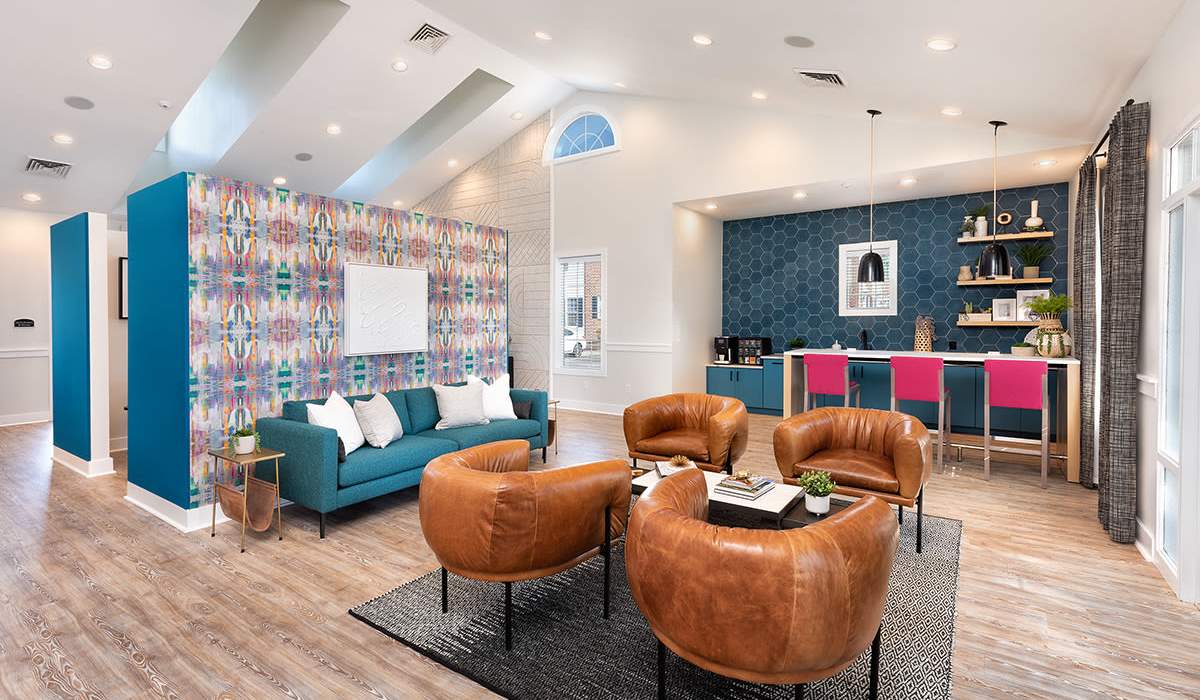 Clubhouse with large comfortable couch and outdoor access at The Landing at Oyster Point in Newport News, Virginia