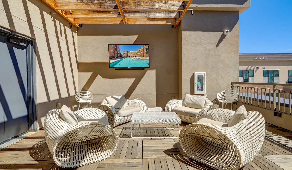 Rooftop seating area with television at One City Block in Denver, Colorado