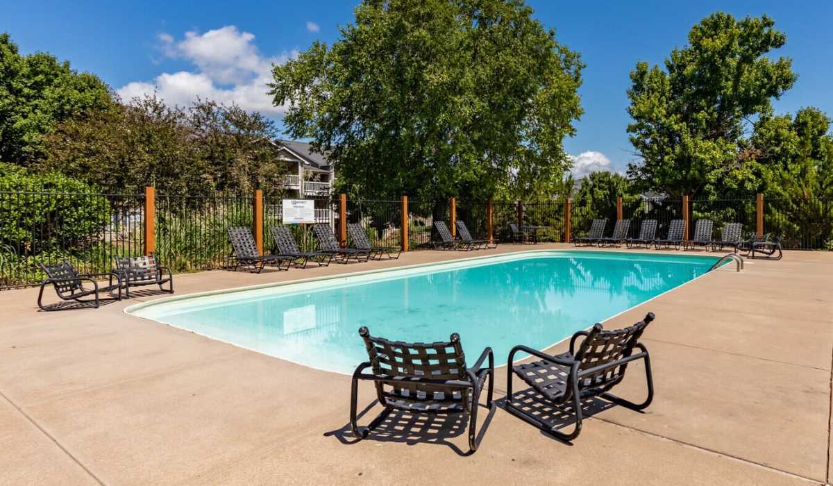 Large pool with poolside chairs at The District At Manhattan Apartments in Manhattan, Kansas