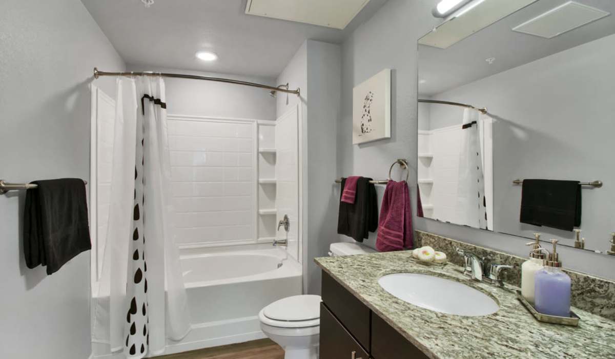 Bright bathroom with mirror, sink and tub at VerraWest in Longmont, Colorado