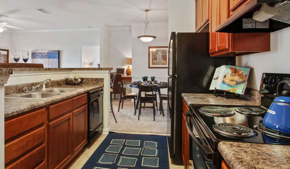Fully equipped kitchen with stainless-steel appliances, granite countertop, refrigerator at Ansley Place in Houma, Louisiana