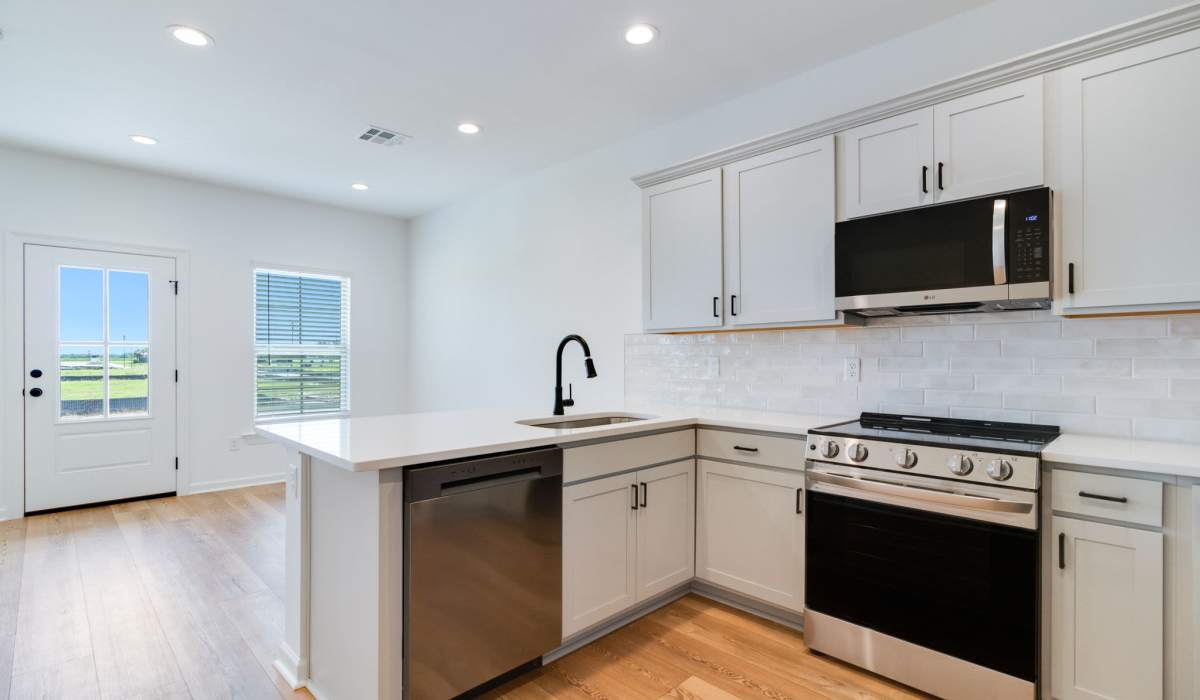 Kitchen and living room in a model home at Cottages at Sugar Mill Pond in Youngsville, Louisiana