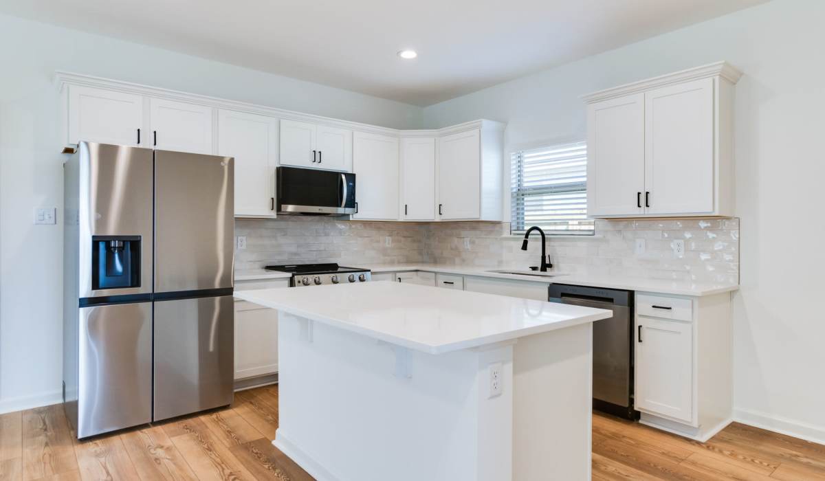 Kitchen with island in a model home at Cottages at Sugar Mill Pond in Youngsville, Louisiana