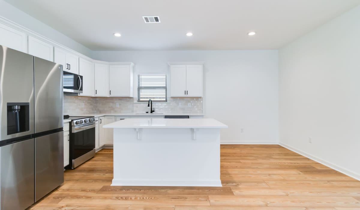 Kitchen and spacious wooden floors at Cottages at Sugar Mill Pond in Youngsville, Louisiana