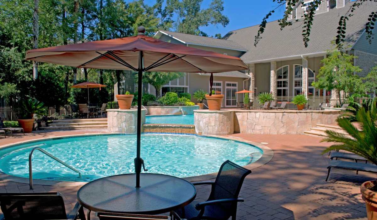 Pool with an umbrella for the shade at Whispering Pines Ranch in The Woodlands, Texas