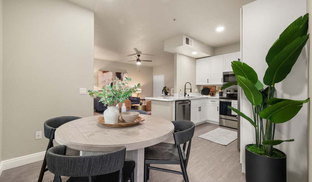 A contemporary kitchen equipped with stainless steel appliances, flowing into a welcoming living room at The Preserve at Creekside in Roseville, California  