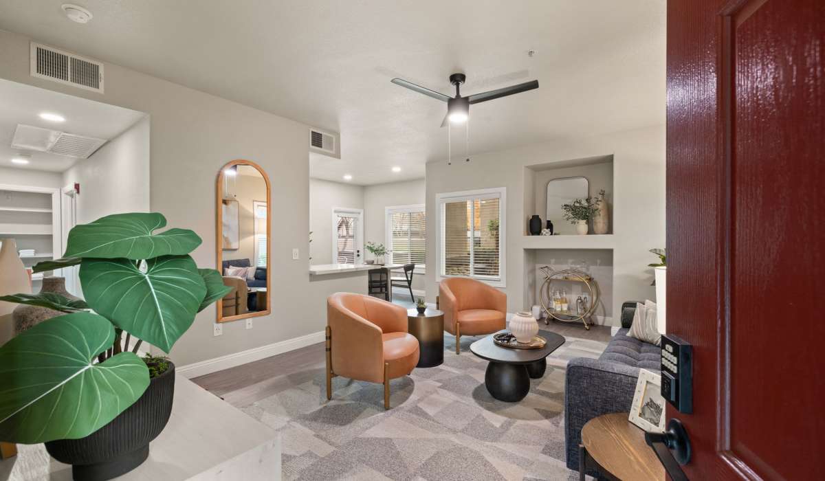 A cozy living room featuring a fireplace, comfortable chairs, and a vibrant plant for a warm atmosphere at The Preserve at Creekside in Roseville, California  