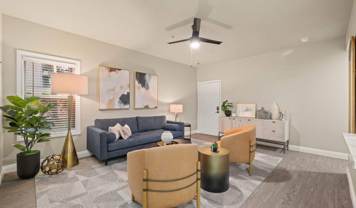A welcoming living room with a fireplace, stylish chairs, and a lush plant, creating a serene environment at The Preserve at Creekside in Roseville, California  