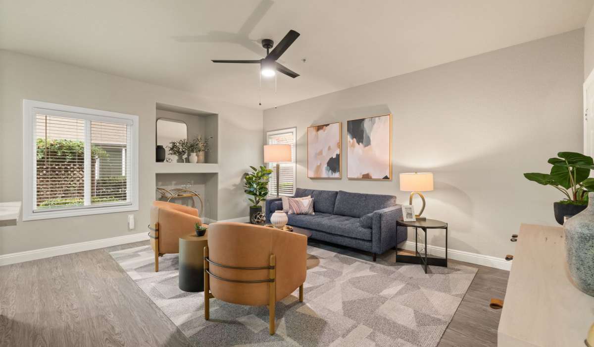 A charming living room showcasing a fireplace, inviting chairs, and a decorative plant for a homely feel at The Preserve at Creekside in Roseville, California  