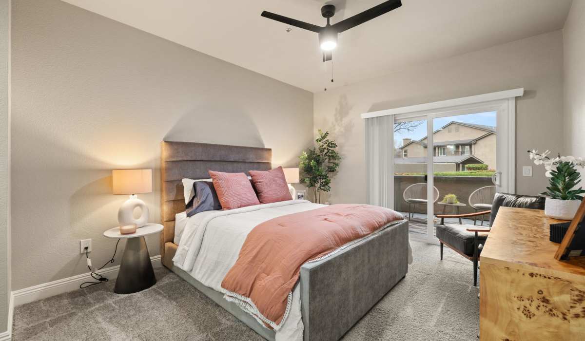 A well-furnished bedroom showcasing a comfortable bed, an elegant dresser, and a door for entry or exit at The Preserve at Creekside in Roseville, California  
