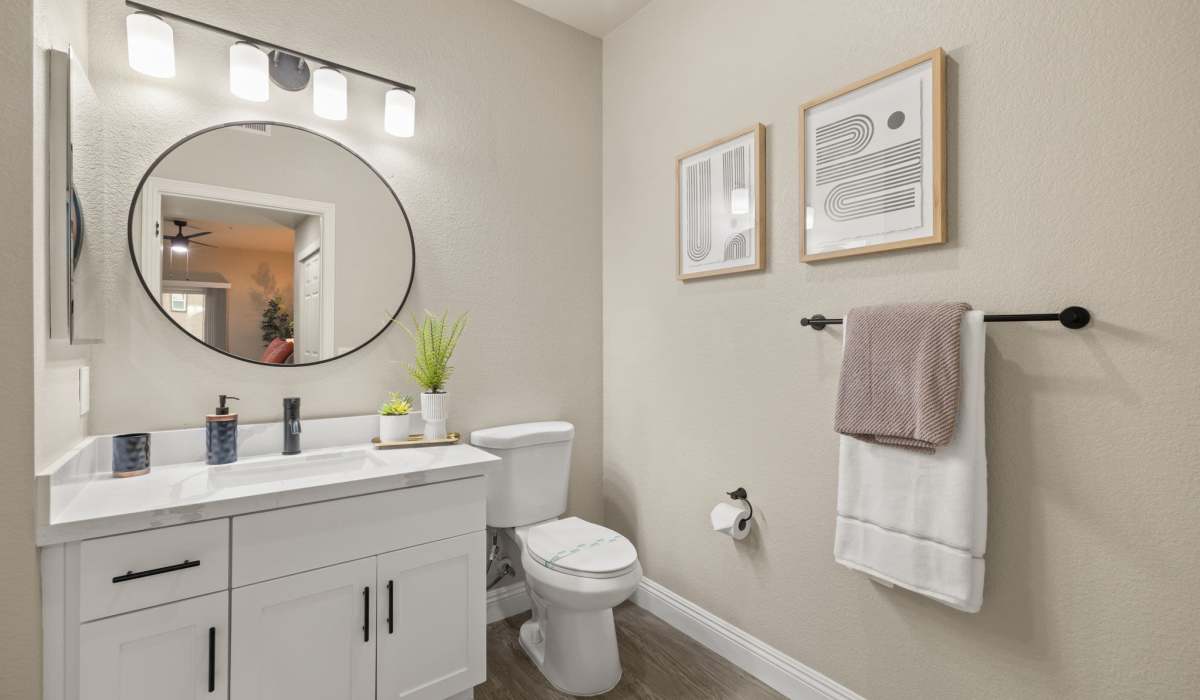 A clean bathroom featuring a white sink, toilet, and mirror, showcasing a modern and minimalist design at The Preserve at Creekside in Roseville, California  