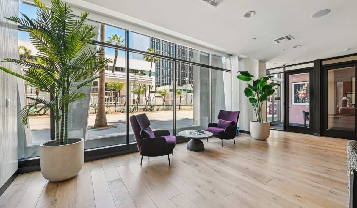 Indoor lounge with tow violet chairs and table at Aster in Long Beach, California