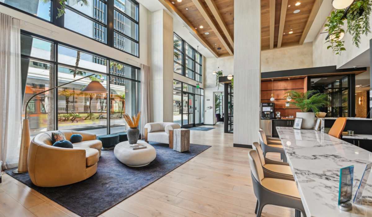 Reception area with comfortable chairs and table on a carpet at Aster in Long Beach, California