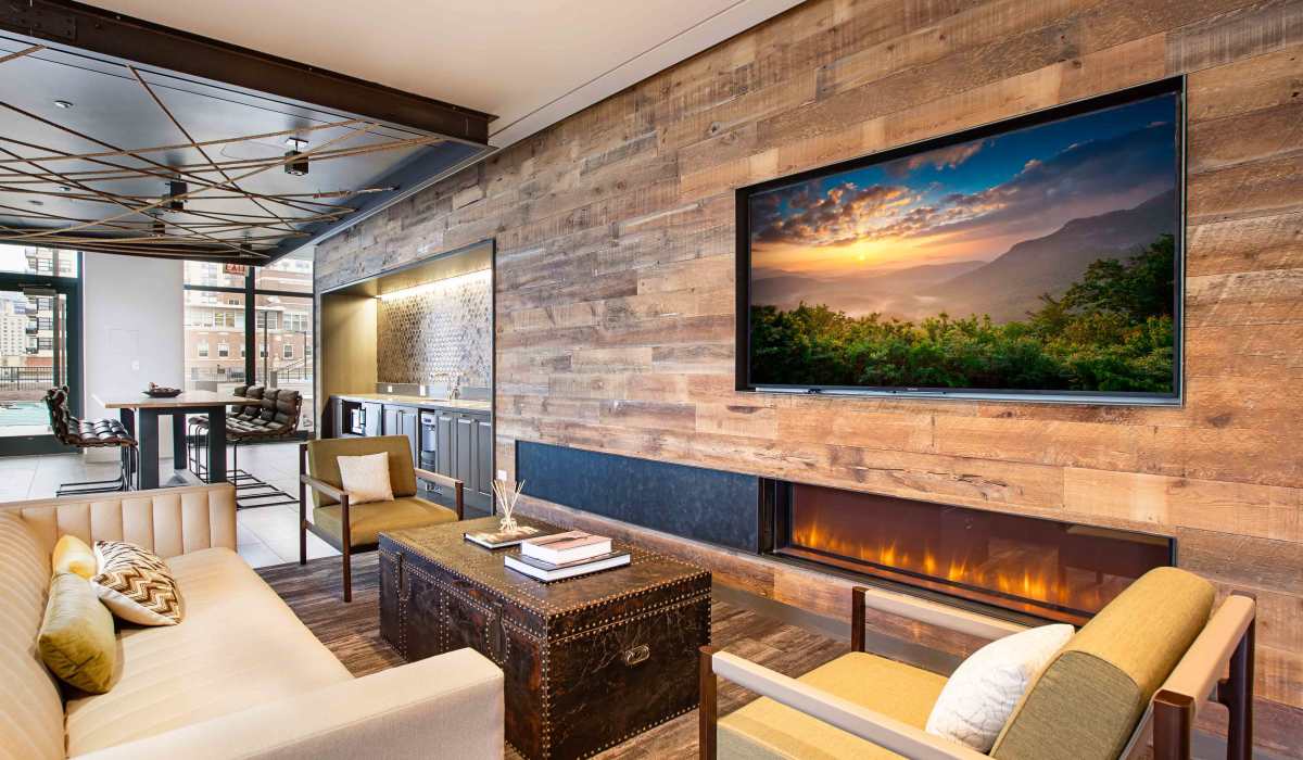 Resident lounge with large TV and fireplace at Exhibit On Superior in Chicago, Illinois