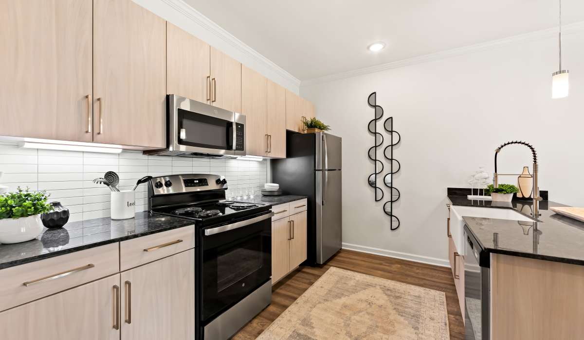 Fully equipped kitchen with granite countertops stainless steel appliances like a refrigerator, stove, and drawer microwave at Elevate at Topside in Louisville, Tennessee
