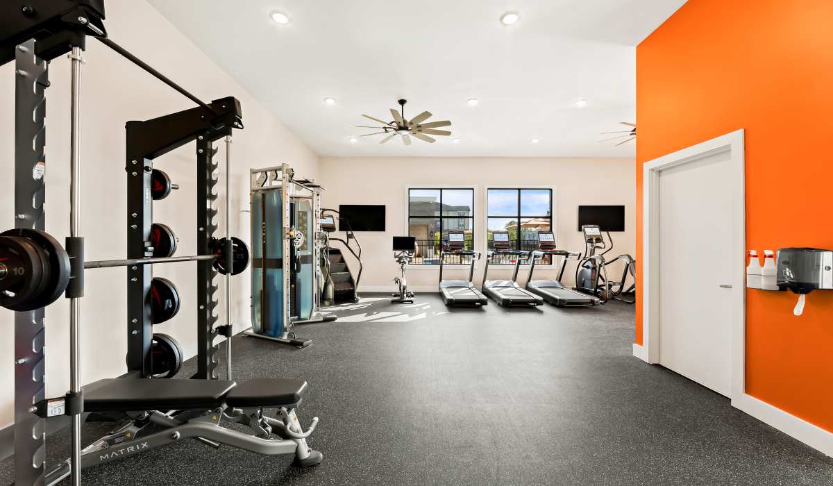 Fully-equipped gym with treadmills, weight machines, and flat-screen TVs at Elevate at Topside in Louisville, Tennessee