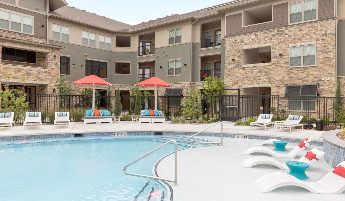 View of swimming pool and lounge beds at Vale Overland Park Apartments in Overland Park, Kansas, 
