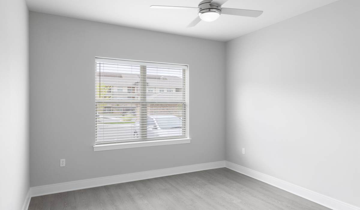 Bright bedroom with large windows and plush carpeting at Vale Overland Park Apartments in Overland Park, Kansas,  