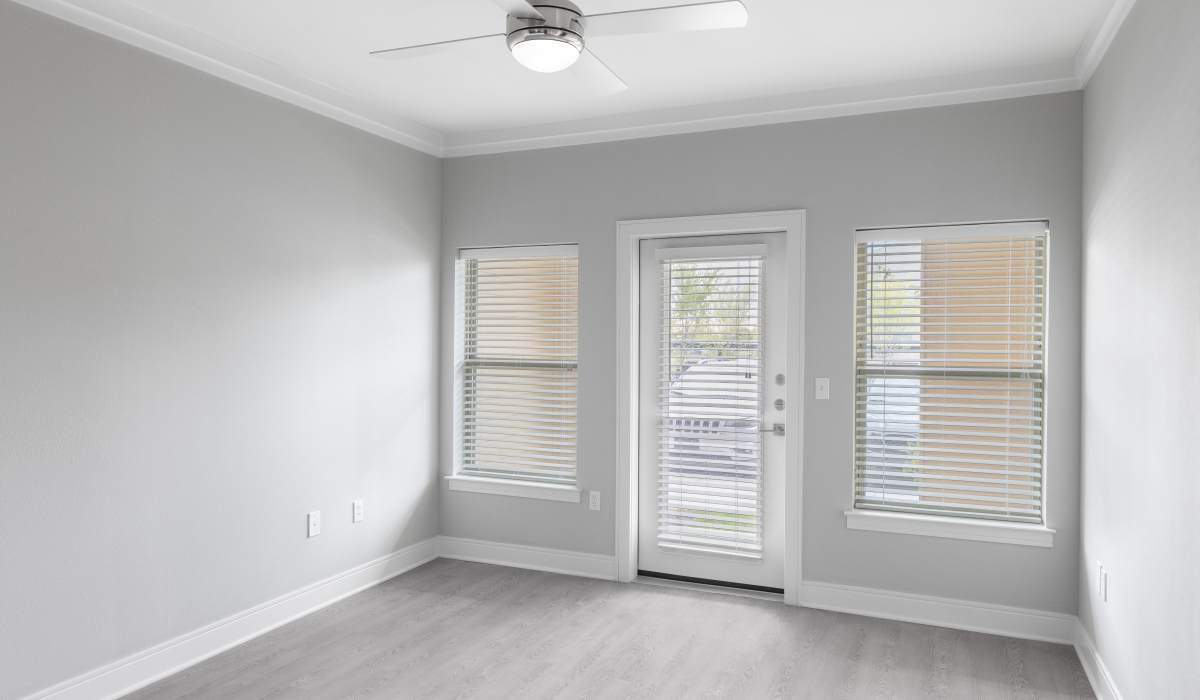 Living room with access to patio through glassdoor at Vale Overland Park Apartments in Overland Park, Kansas,  