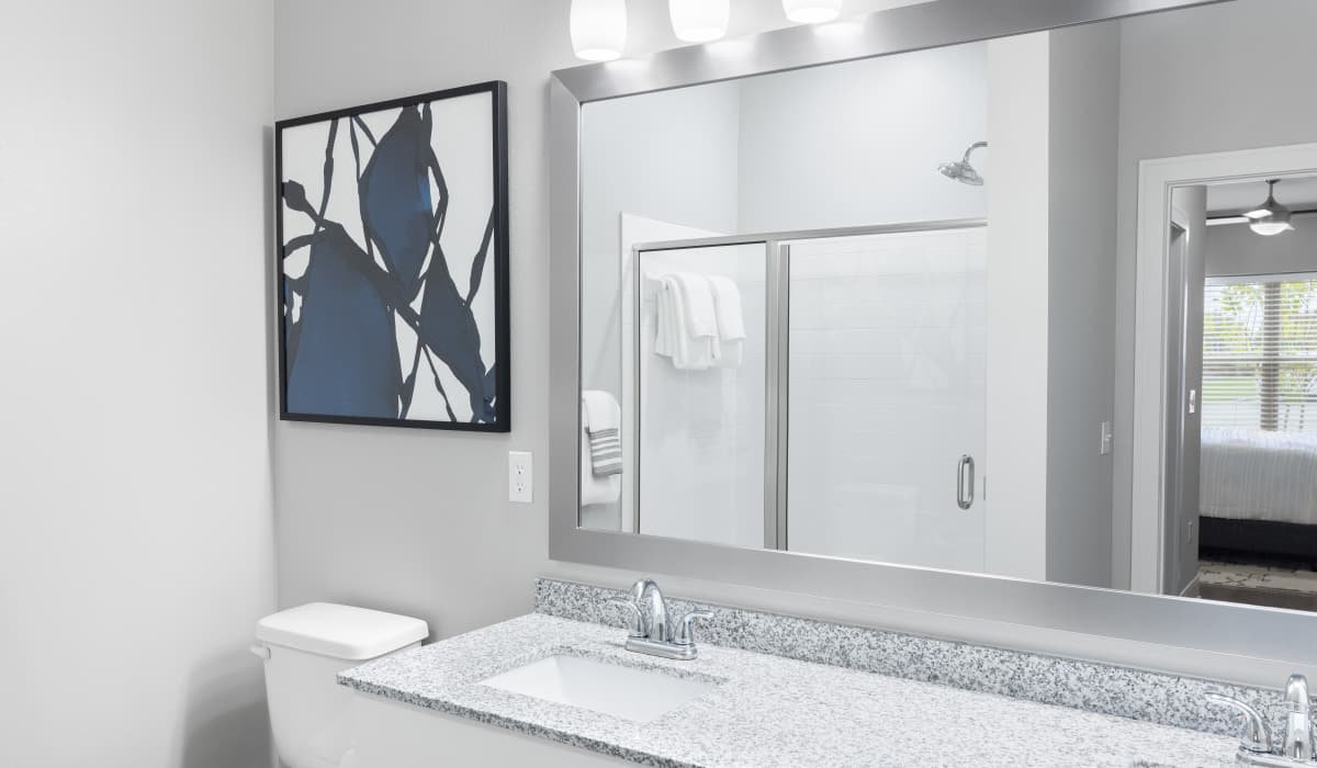 Bathroom with large mirror at Vale Overland Park Apartments in Overland Park, Kansas,  