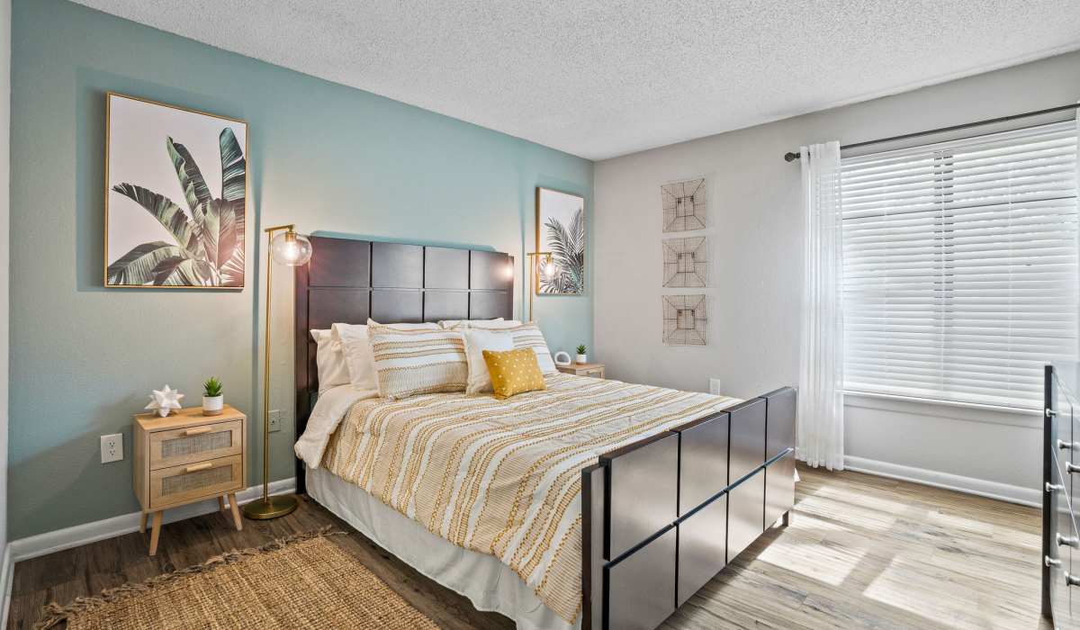 Large bedroom with hardwood floors and dresser with mirror at Waterstone At Carrollwood in Tampa, Florida