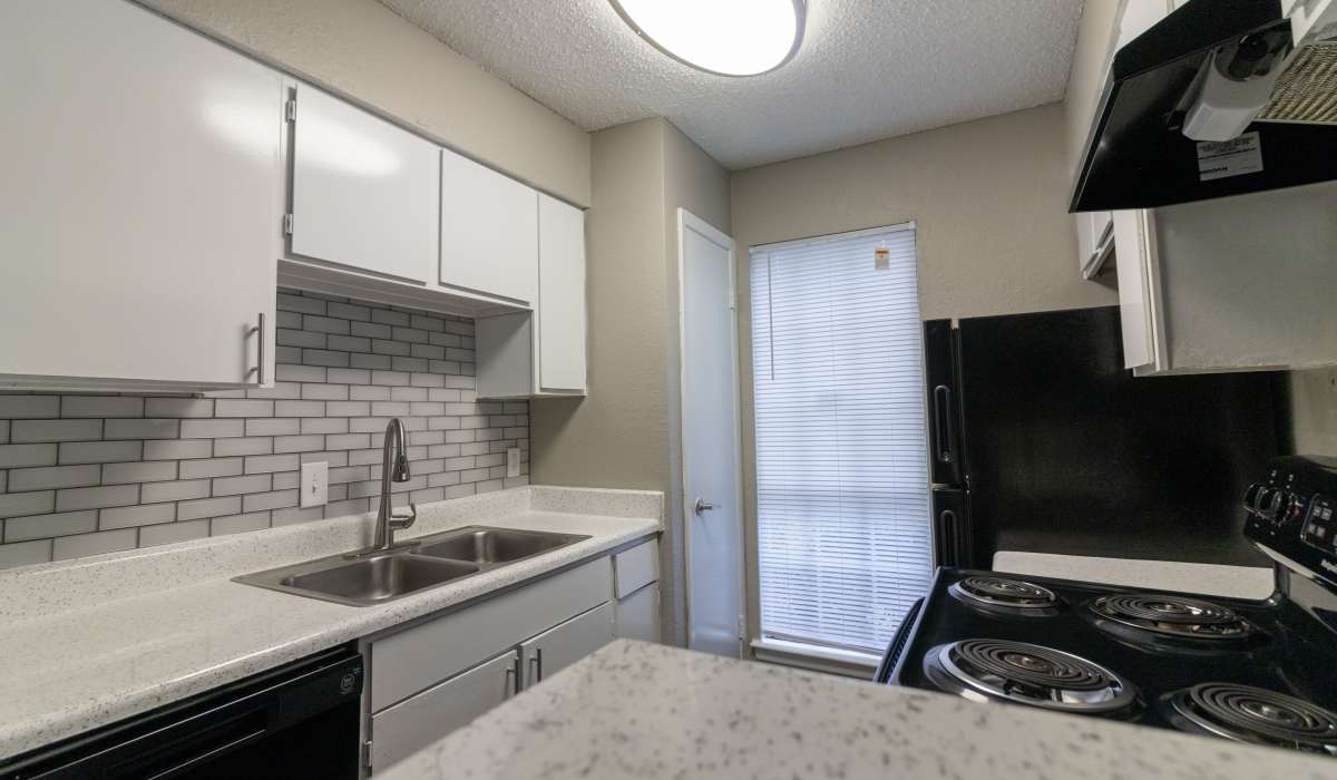 Cozy kitchen with white cabinets at Oak Ridge Apartments in San Antonio,Texas