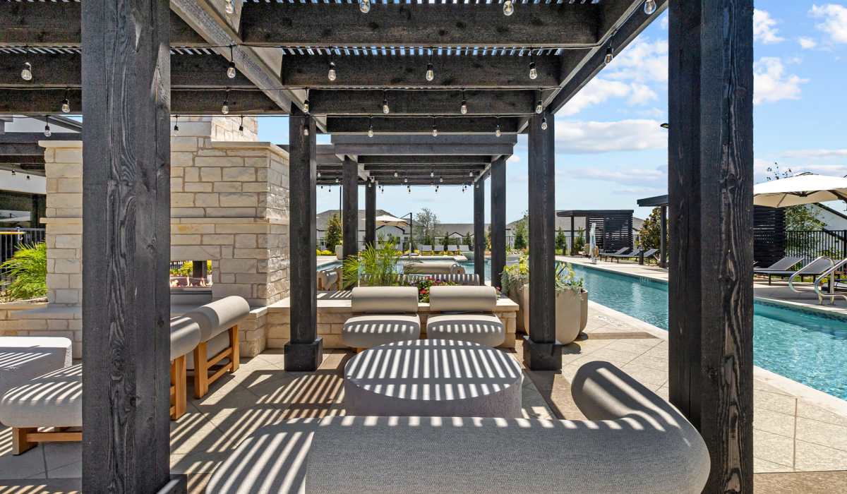 Covered seating by the pool at Luxe Of Buda in Buda, Texas
