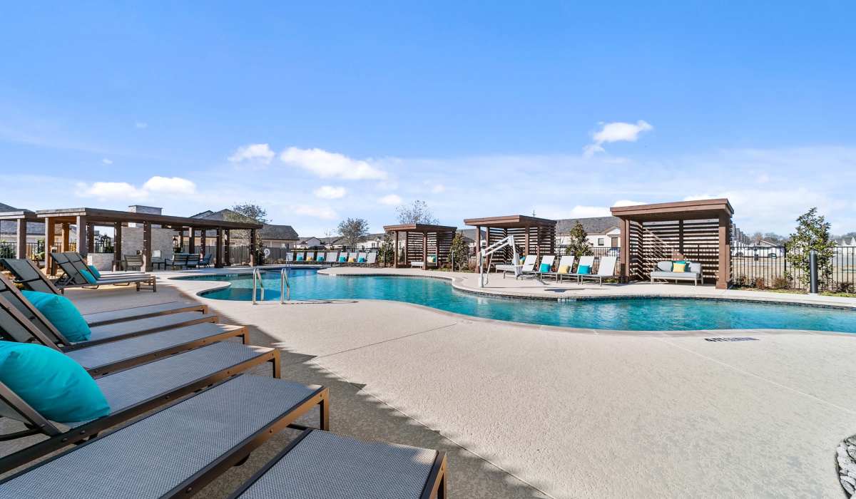 Lounge chairs by the resort-style pool at The Luxe Of Mckinney in Mckinney, Texas