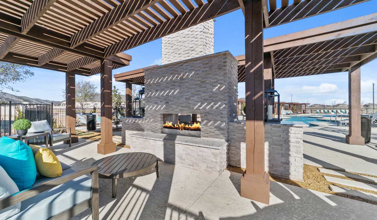 Outdoor fireplace by the pool at The Luxe Of Mckinney in Mckinney, Texas