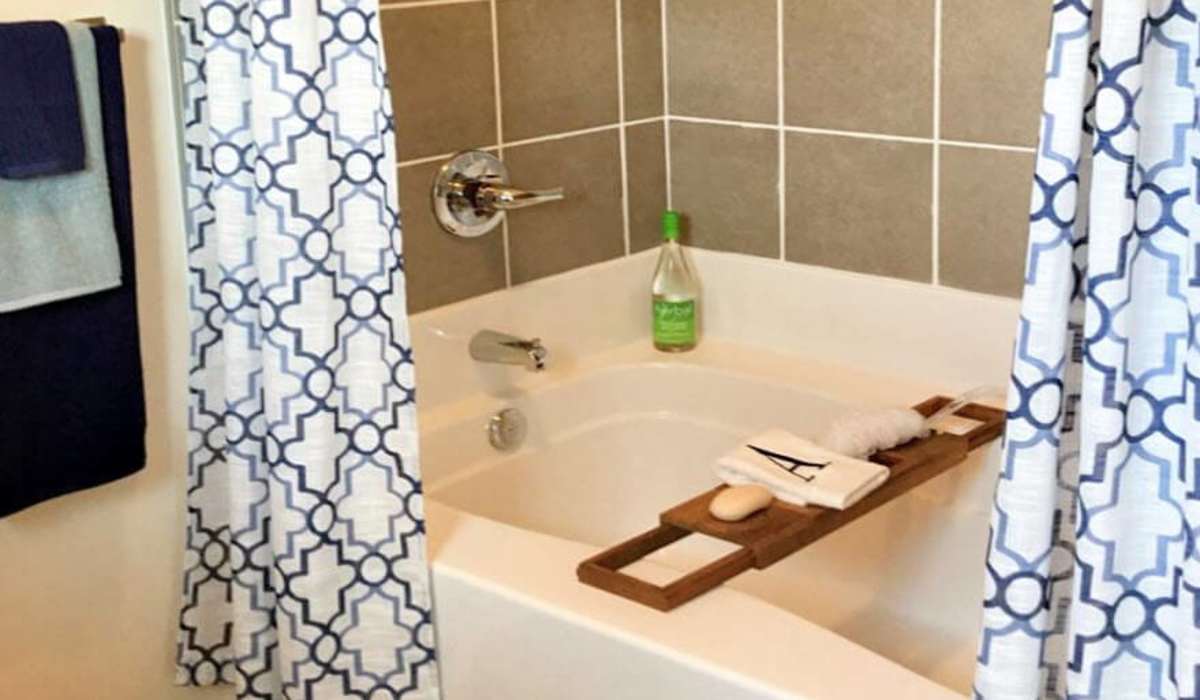 Bath tub along with shower curtains in the bathroom at Palisades at The Park in Greenville,South Carolina