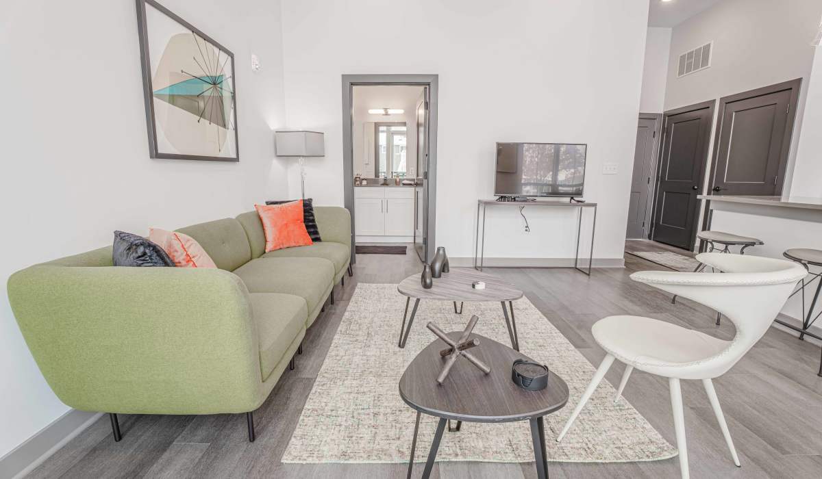 living room with green color sofa at The Apartments at 1st on Main in Carmel, Indiana 