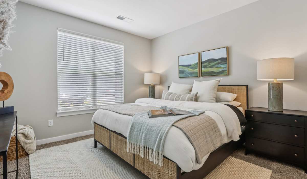 Well-lit bedroom with a bed and a large window at Founders Pointe Apartments in Franklin, Indiana