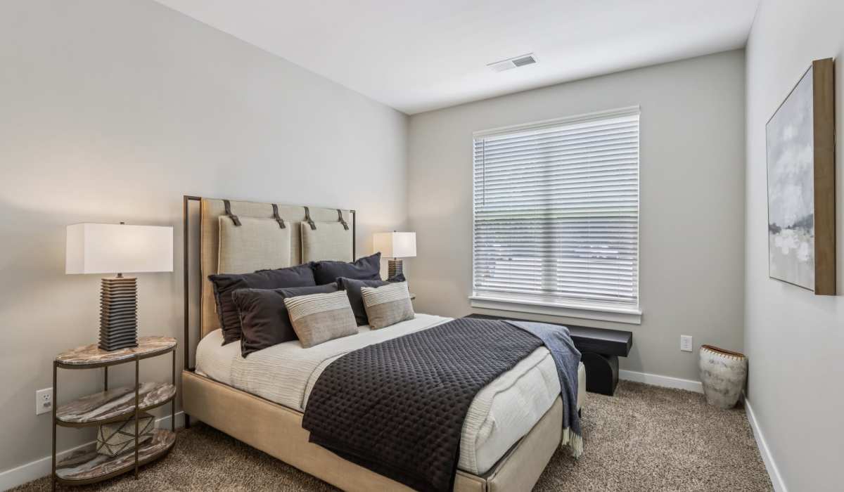 Bedroom with a bed and a side lamp at Founders Pointe Apartments in Franklin, Indiana