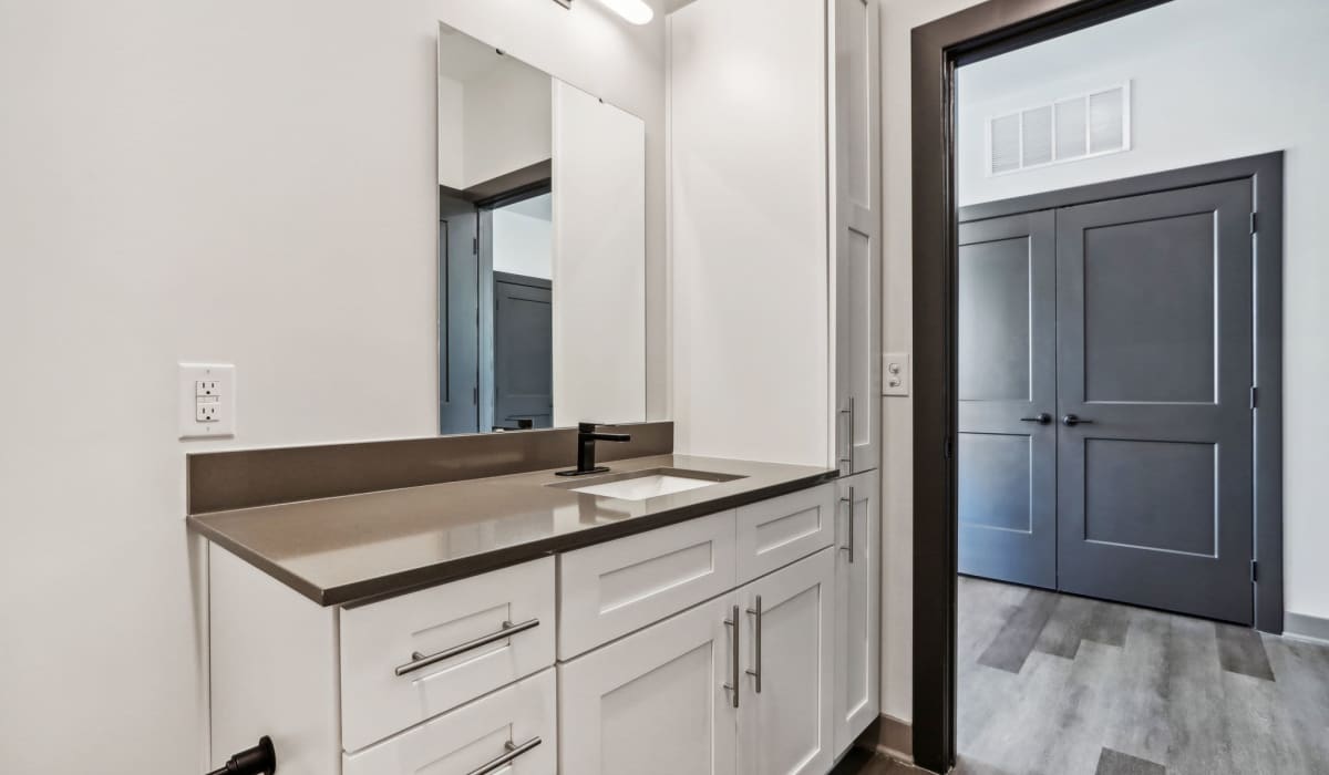 Bathroom with vanity mirror at The Apartments at 1st on Main in Carmel, Indiana